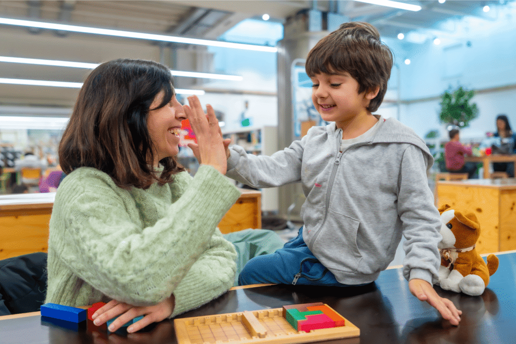 Kind mit Mutter friedlich beim Spielen. Mutter arbeitet mit logischen Konsequenzen